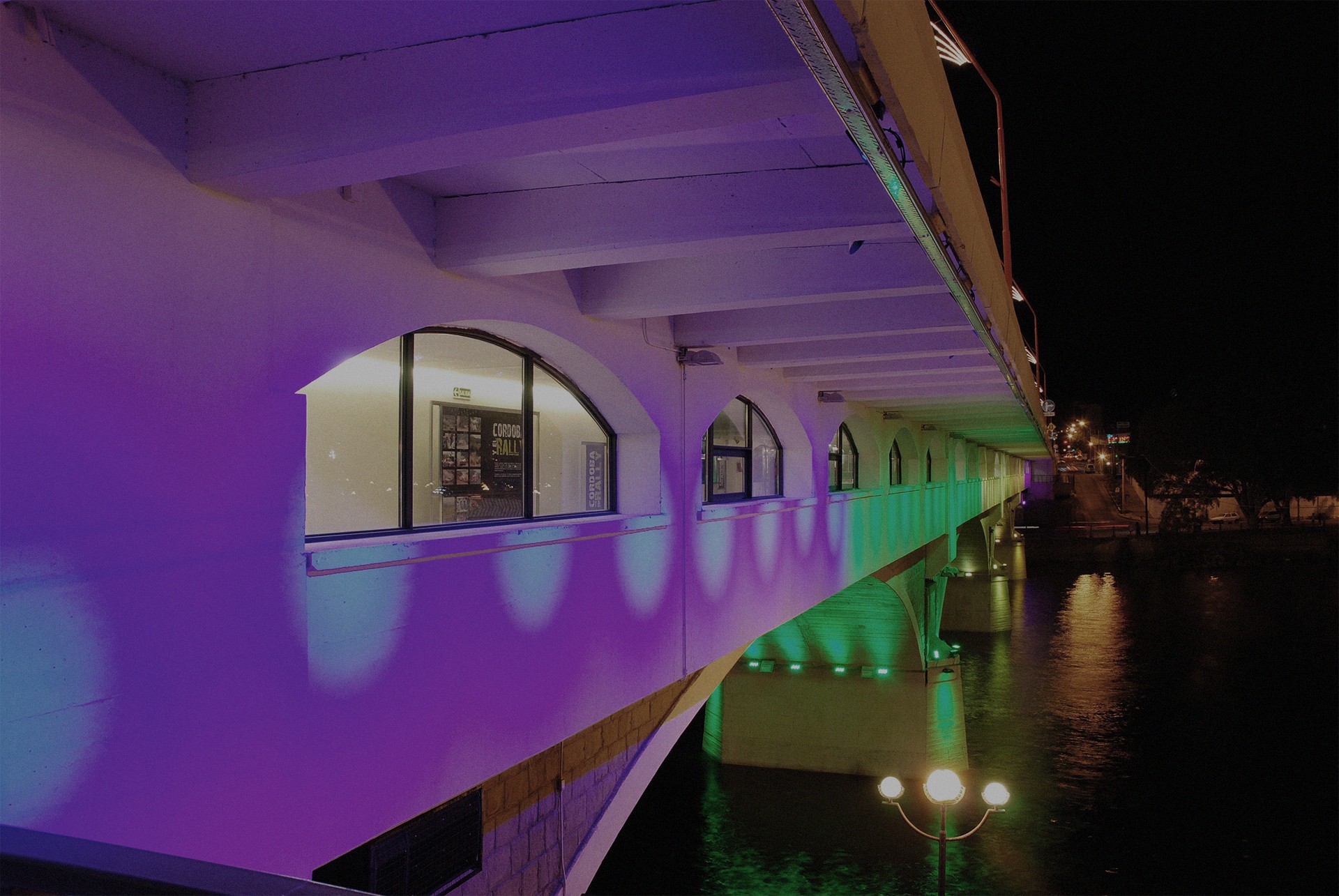 Puente iluminado sobre el agua en Villa Carlos Paz